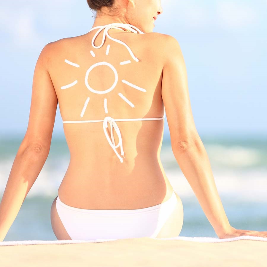 donna in spiaggia con protezione solare
